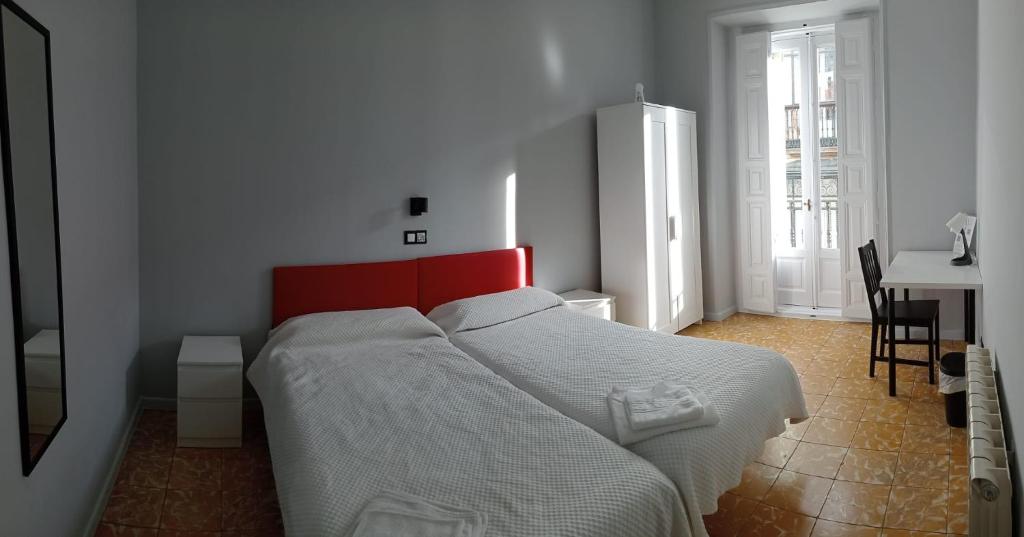 a bedroom with a large bed with a red headboard at Hostal Yolanda in Madrid