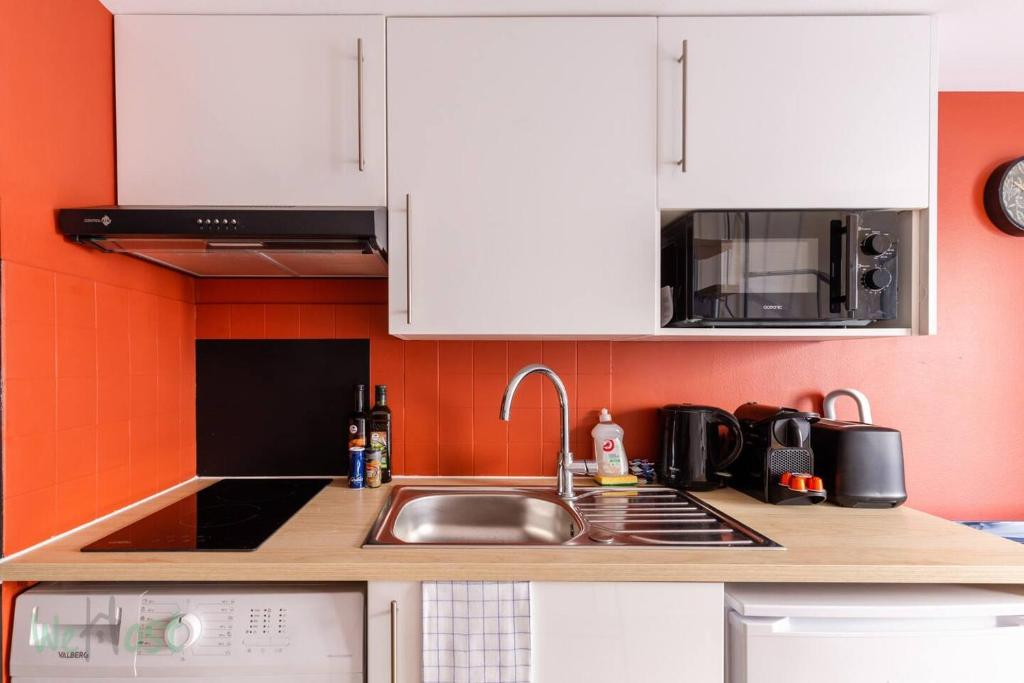 a kitchen with a sink and a microwave at Duplex-Université in Lyon