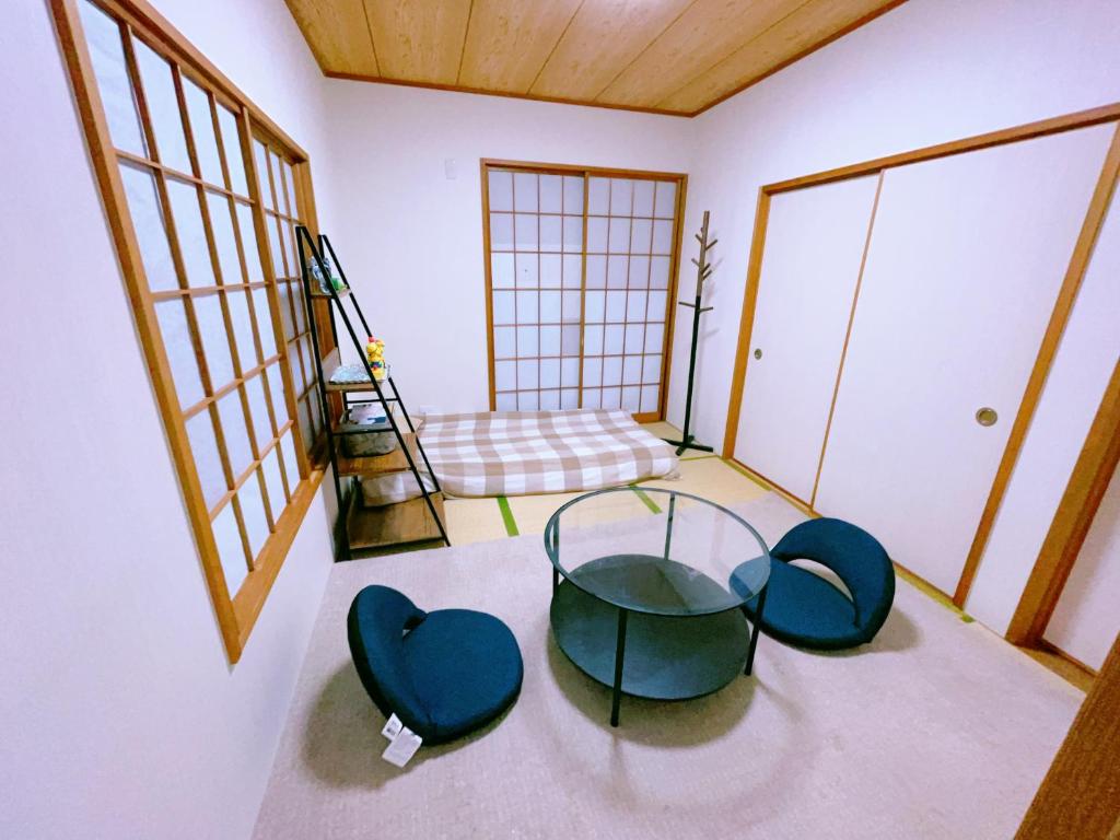 een kamer met een glazen tafel en 2 stoelen bij Miyama House in Hachioji