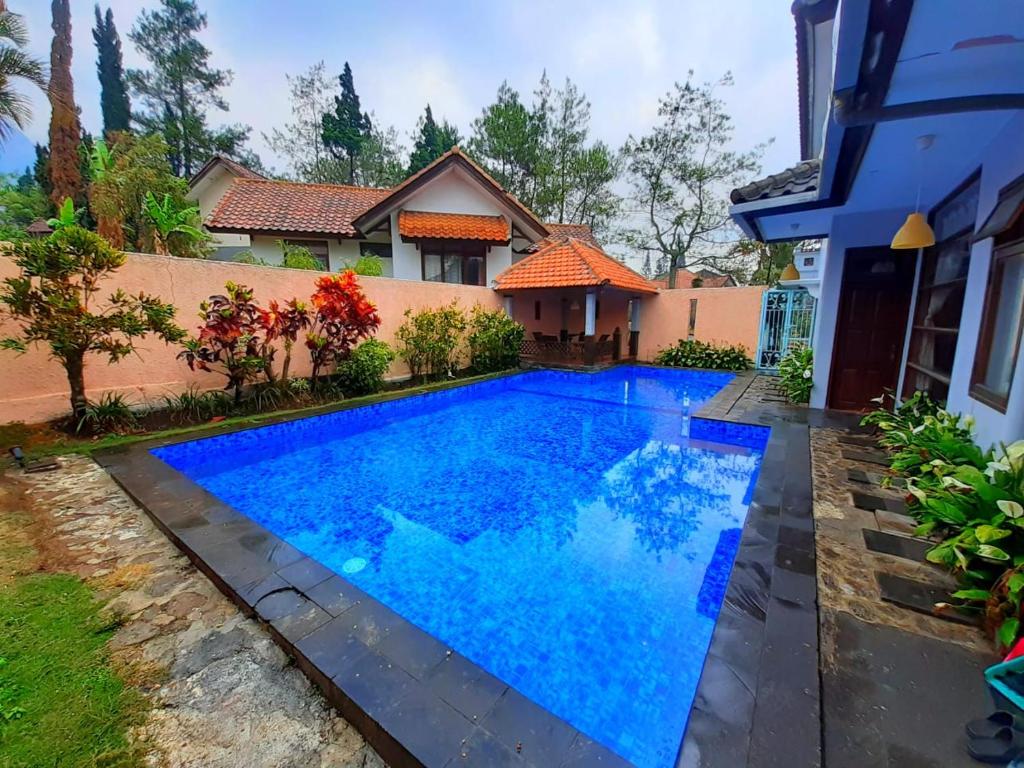 - une piscine en face d'une maison dans l'établissement villa batu pandermanhill 4BR+swimming pool, à Batu