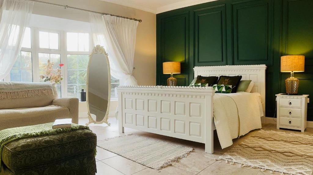 um quarto com uma cama e uma parede verde em Beaufort House Accomodation em New Ross