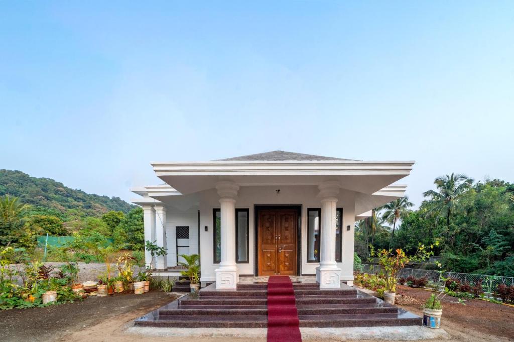 a white house with a red carpet in front of it at Happy Stay Villa - Kashid beach in Kashid