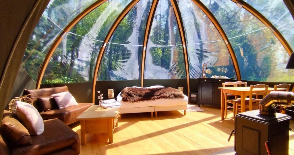 salon z dużą szklaną kopułą w obiekcie Bulle forestière - Etat Nature w mieście Magnières