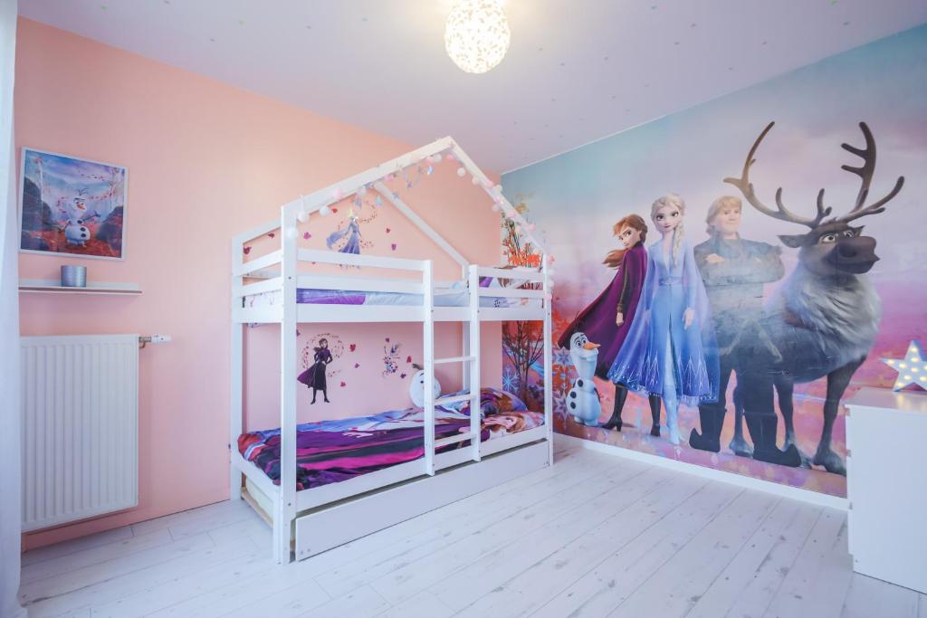 セリにあるAir-conditioned apartment, walking distance to disney - DISNEY MAGICAL HOMES, PARISの子供部屋 ベッド1台と壁画付きのベッドルーム1室が備わります。