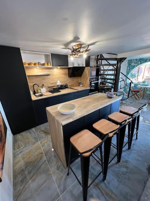 - une cuisine avec un comptoir et quelques tabourets dans l'établissement Villa moderne 3 chambres double , proche de la mer, le Micocoulier quartier sainte Marguerite, à La Garde