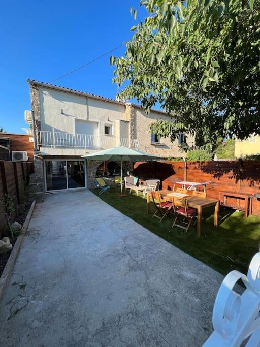 a patio with a table and chairs in front of a building at Villa moderne 3 chambres double , proche de la mer, le Micocoulier quartier sainte Marguerite in La Garde