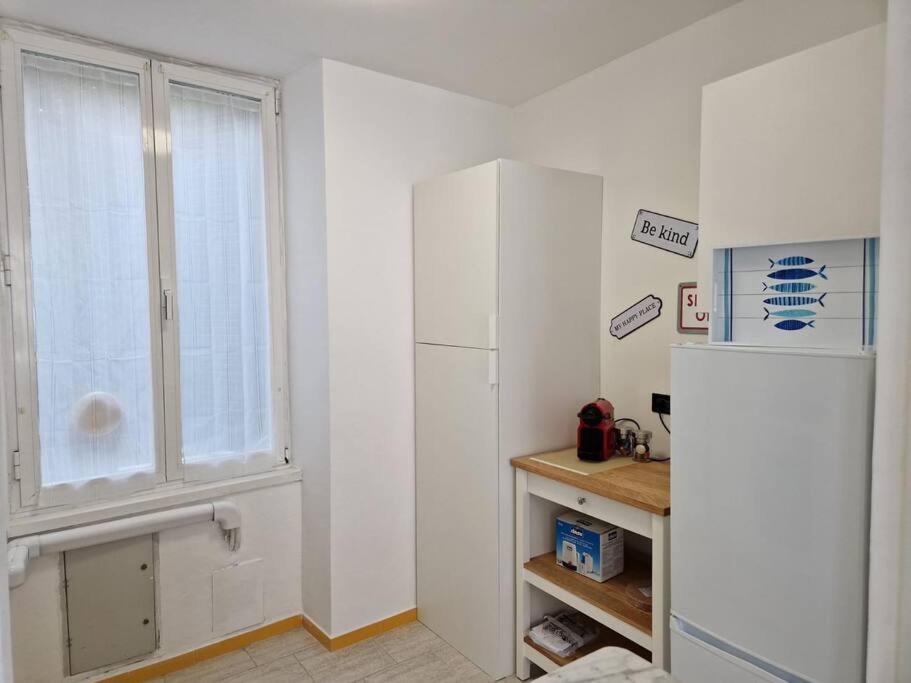 a kitchen with a white refrigerator and a window at Appartamento Profumo di Mare in Camogli