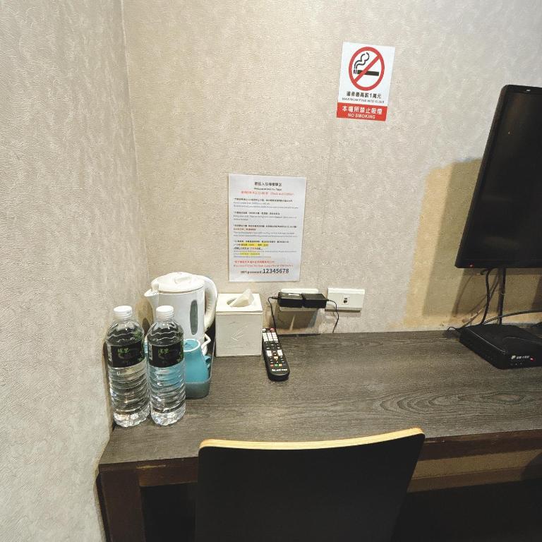 a desk with a phone and water bottles on it at Main Inn Taipei in Taipei