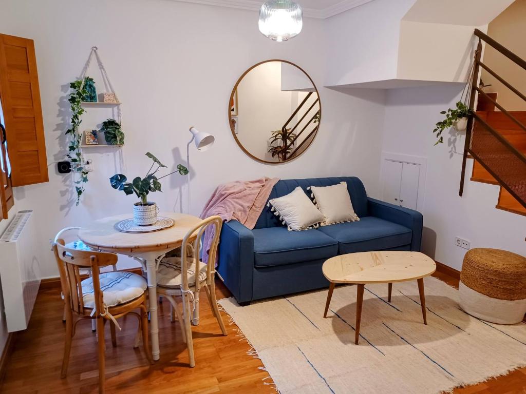 uma sala de estar com um sofá azul e uma mesa em Casa El Tesorillo em Toledo