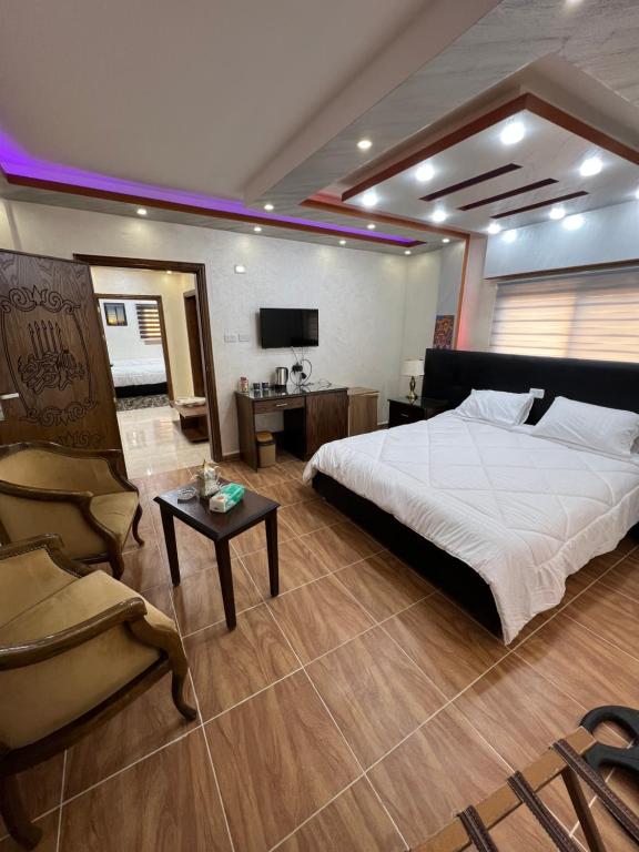 a large bedroom with a large bed and a chair at Petra balcony apartment in Wadi Musa