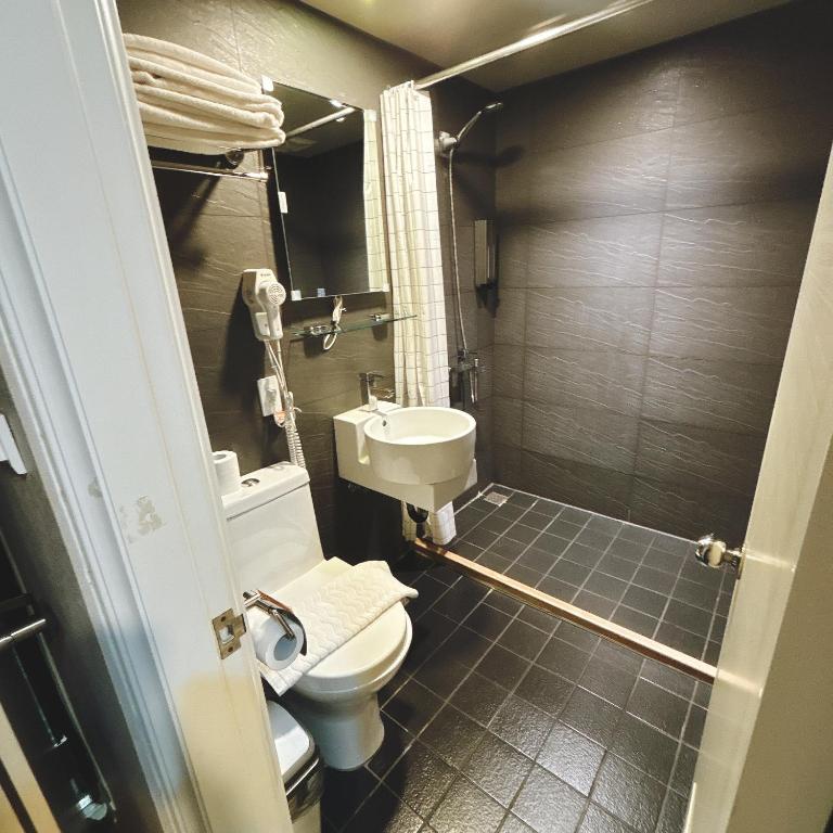 a small bathroom with a toilet and a sink at Main Inn Taipei in Taipei