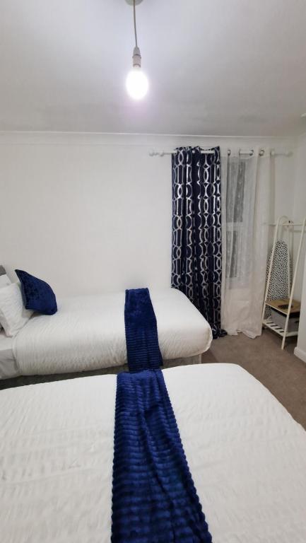 een kamer met 2 bedden en een raam bij Beautiful 2-Bed House in Gillingham in Gillingham