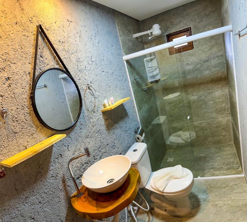 uma casa de banho com um chuveiro, um WC e um espelho. em Chalés Milagres Beach em São Miguel dos Milagres