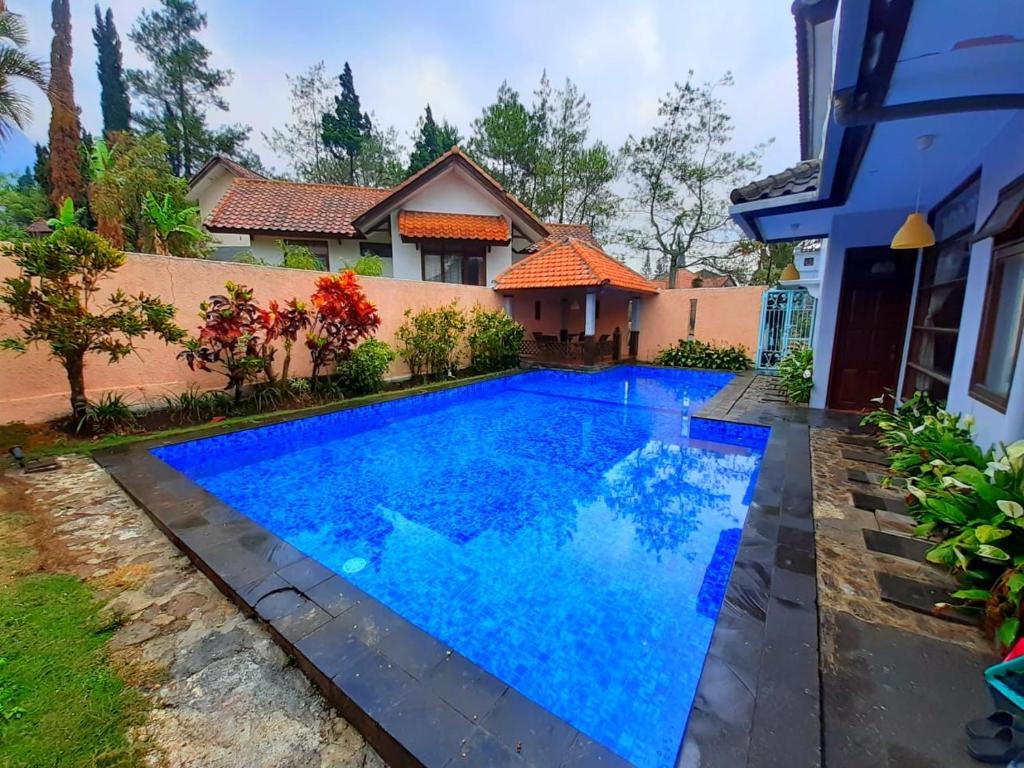 ein Pool vor einem Haus in der Unterkunft Villa batu malang swimming pool in Batu