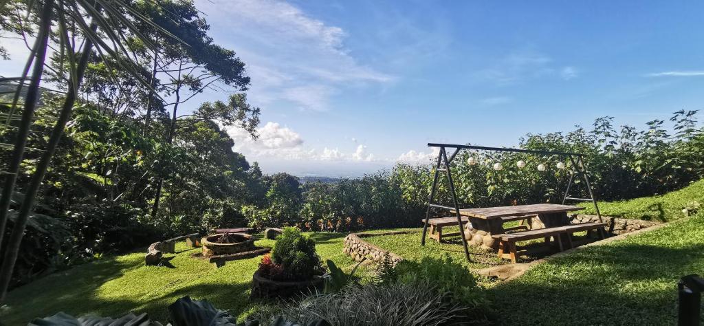 Pilar的住宿－Ilaya Highland Resort，一个带野餐桌和秋千的花园