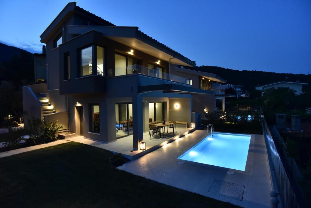 a villa with a swimming pool in front of a house at Welcome Inn in Paleo Tsifliki