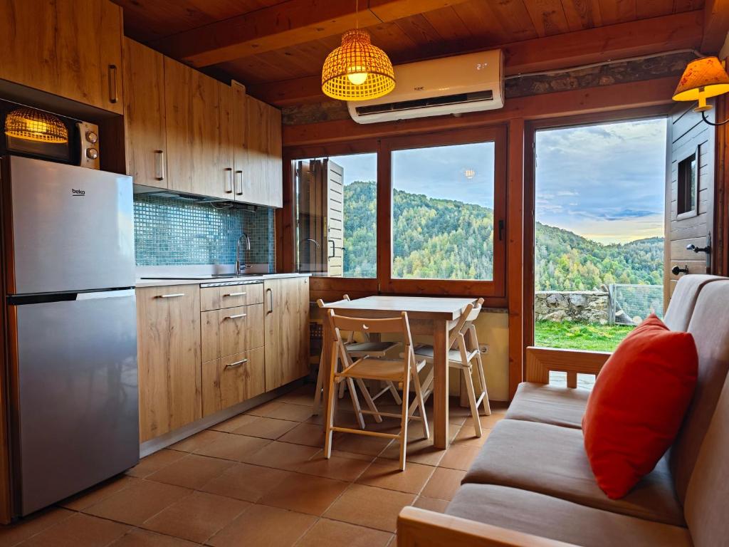 uma cozinha com um sofá e uma mesa com vista em La Cabanya de Can Menut em Molló