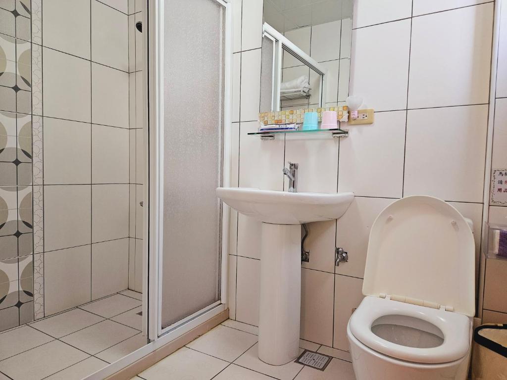 a bathroom with a toilet and a sink and a shower at Sunny Sun B&amp;B in Taitung City