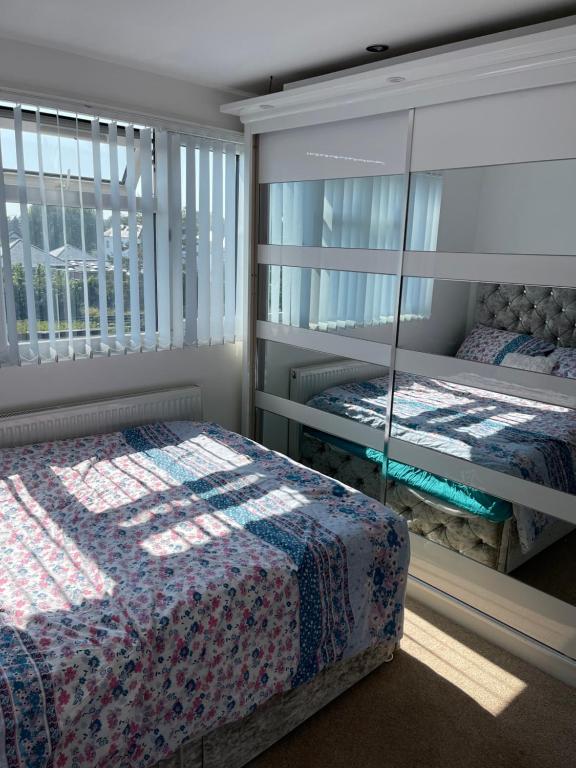 1 Schlafzimmer mit 2 Betten und einem Spiegel in der Unterkunft NISHAT & AMAAN in Broadwater