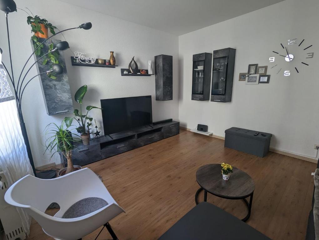 a living room with a television and a white chair at Ferienwohnung Nina direkt in Zentrum in Bad Wildbad