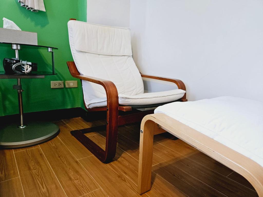 a bedroom with a bed and a chair next to a bed at Sunny Sun B&amp;B in Taitung City