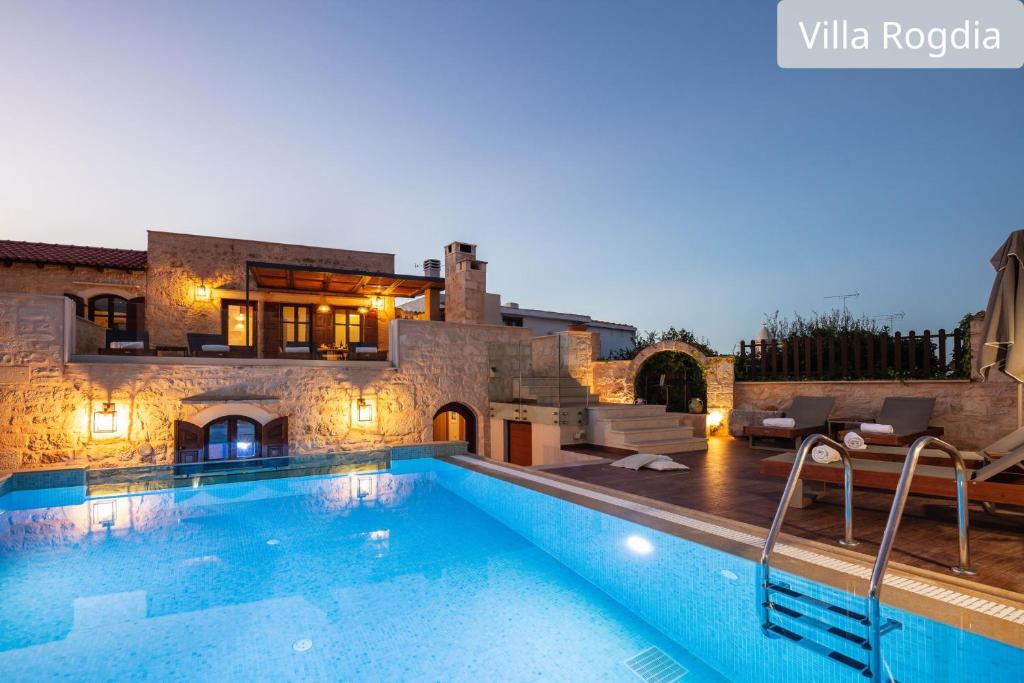a villa with a swimming pool in front of a building at Atsipopoulo Villas in Atsipopoulo