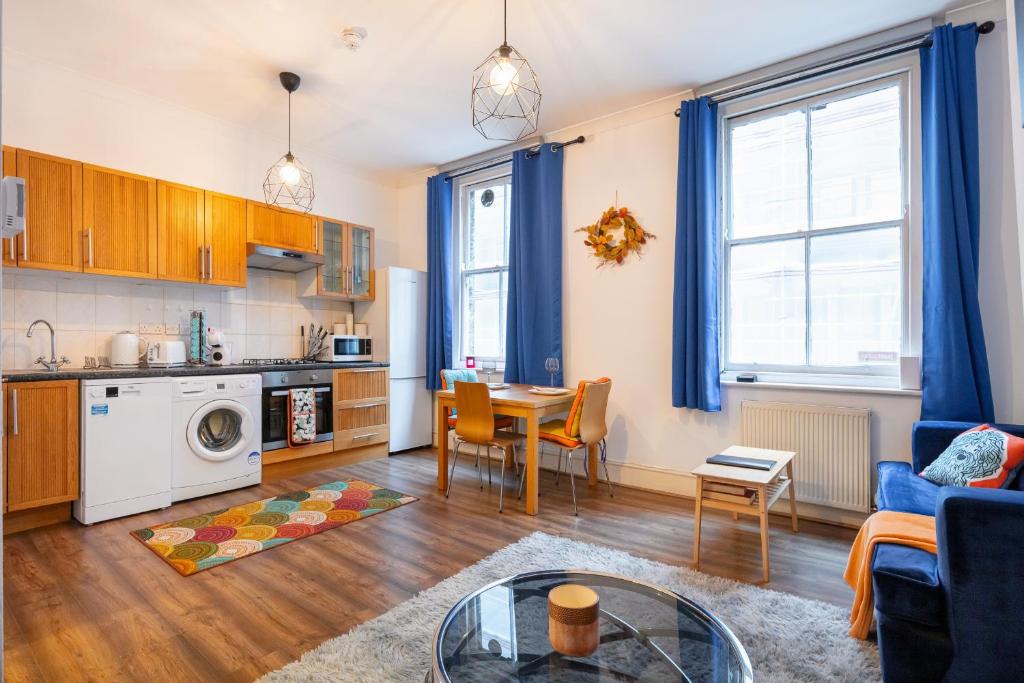 uma cozinha e uma sala de estar com mesa e cadeiras em Lovely One Bed in the Heart of Covent Garden em Londres
