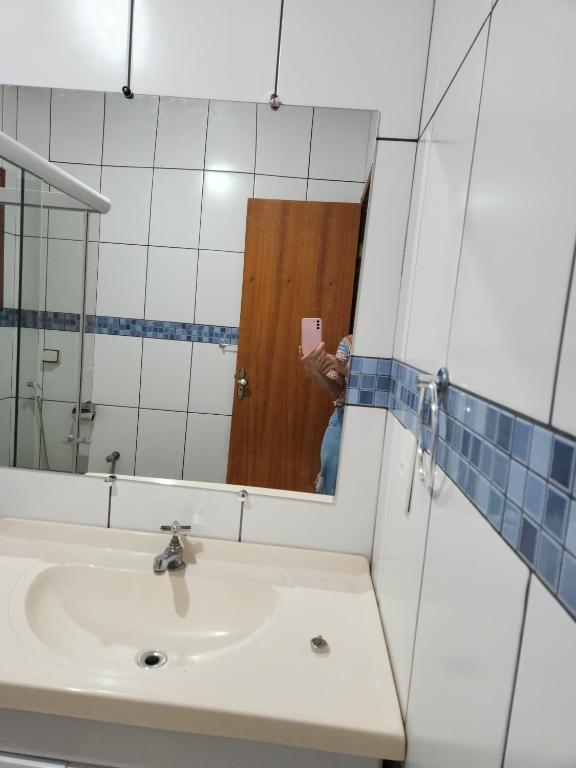 eine Person, die ein Bild von einem Badezimmerspiegel macht in der Unterkunft Hospedagem Vanilda in Nova Friburgo