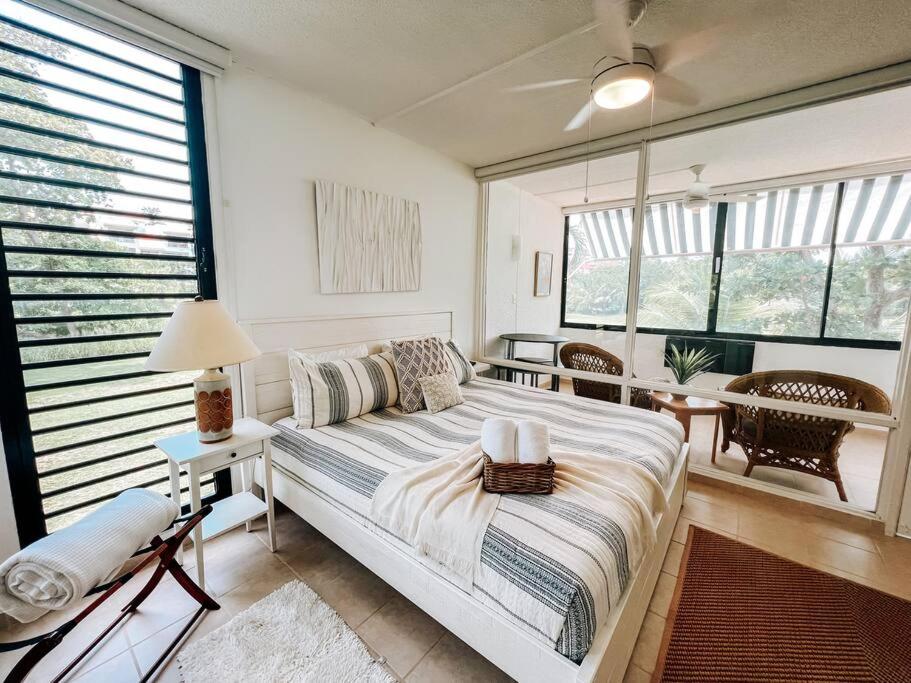 1 dormitorio con cama, mesa y algunas ventanas en Beach Village Comfy & Cozy Apt Palmas Del Mar 73, en Buena Vista
