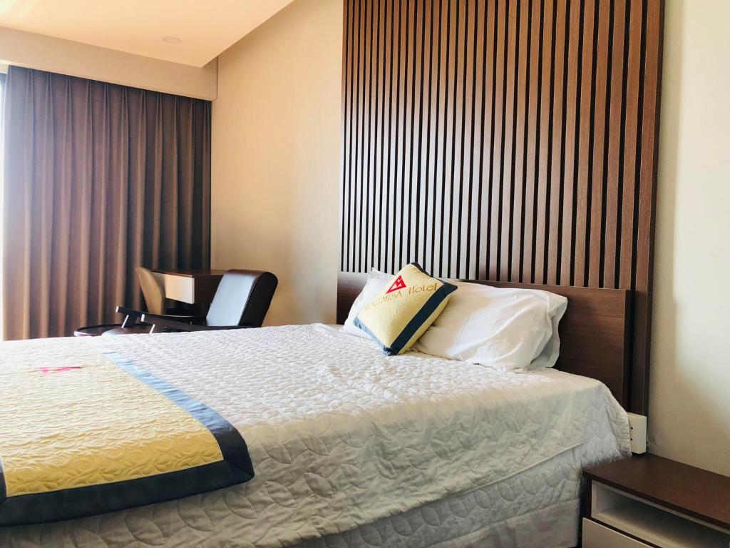 ein Hotelzimmer mit einem Bett mit einem Buch darauf in der Unterkunft Apec Mandala hotel & suites Hải dương in Hải Dương