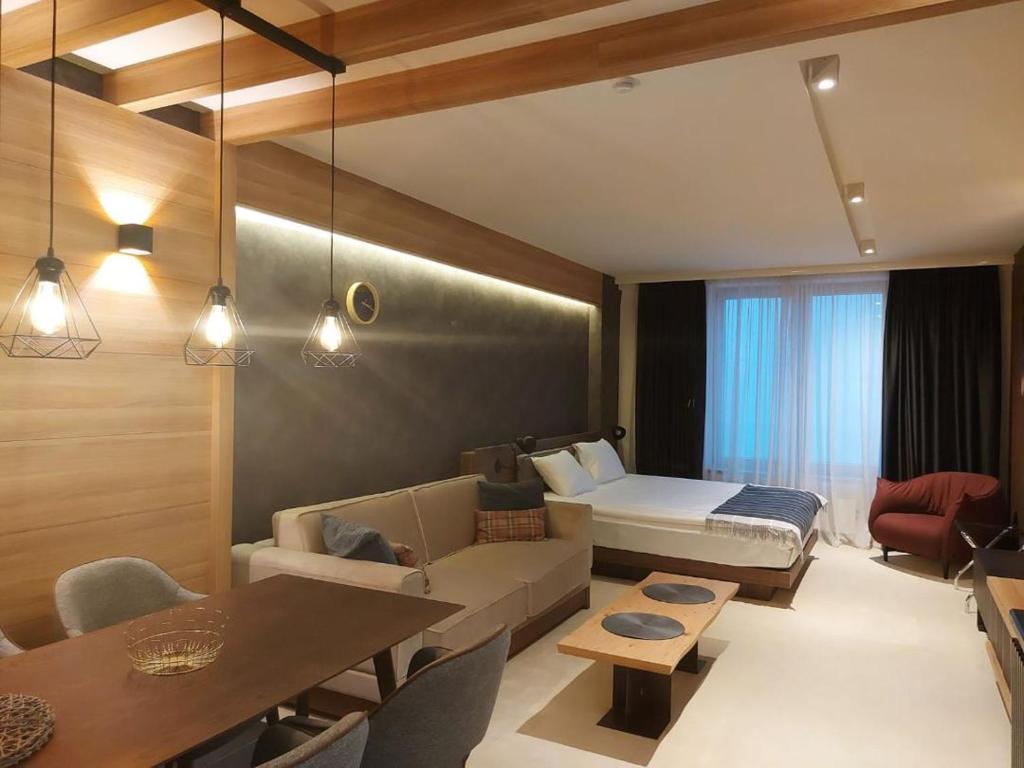 um quarto com uma cama, um sofá e uma mesa em Woodside apartments Kopaonik em Kopaonik