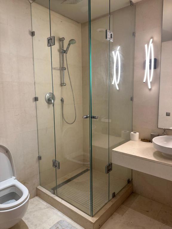 uma casa de banho com um chuveiro, um WC e um lavatório. em Apart luxe em Casablanca