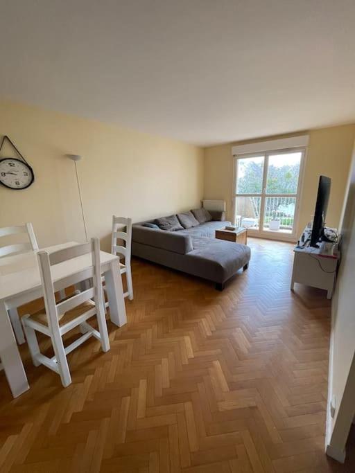 uma sala de estar com um sofá e uma mesa em Logement entier : appartement ⸱ Chez Slimane em Massy