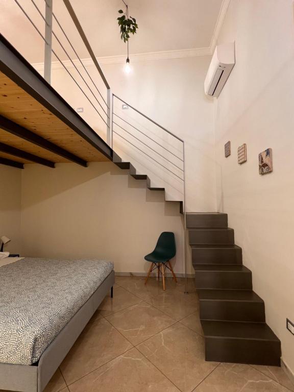 ein Schlafzimmer mit einer Treppe neben einem Bett in der Unterkunft Casa Dom-Ino 25 in Bagheria