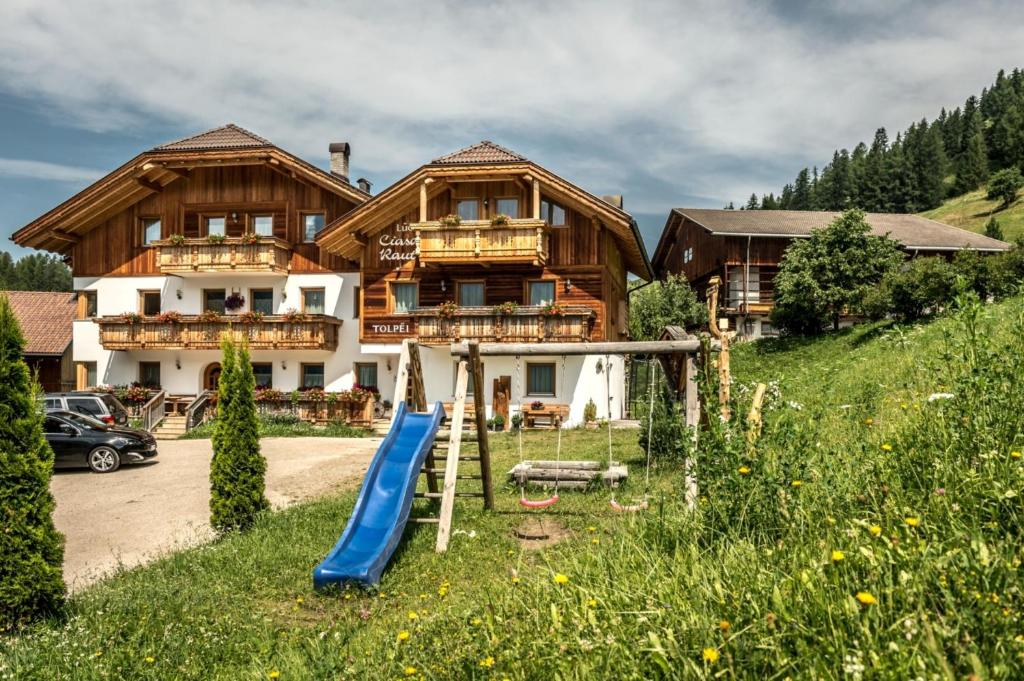 une maison avec un toboggan devant elle dans l'établissement Ciasa Raut, à La Valle