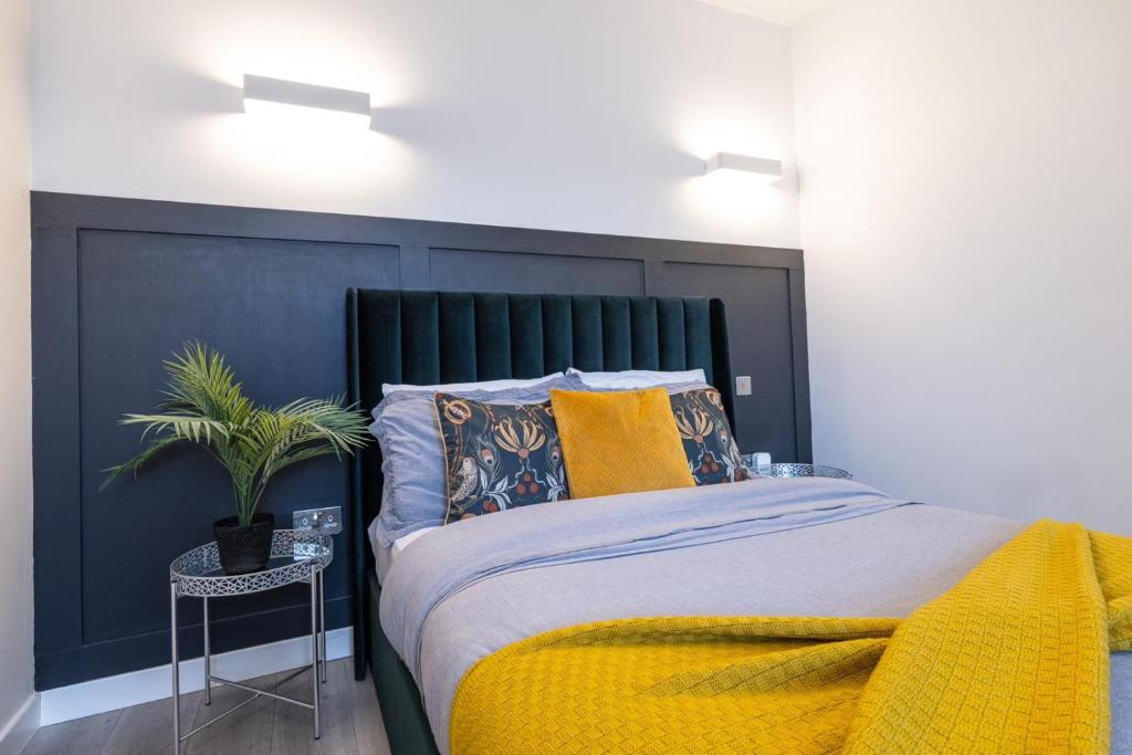 a bedroom with a large bed with a black headboard at elegant apartment 3 in Milton Keynes