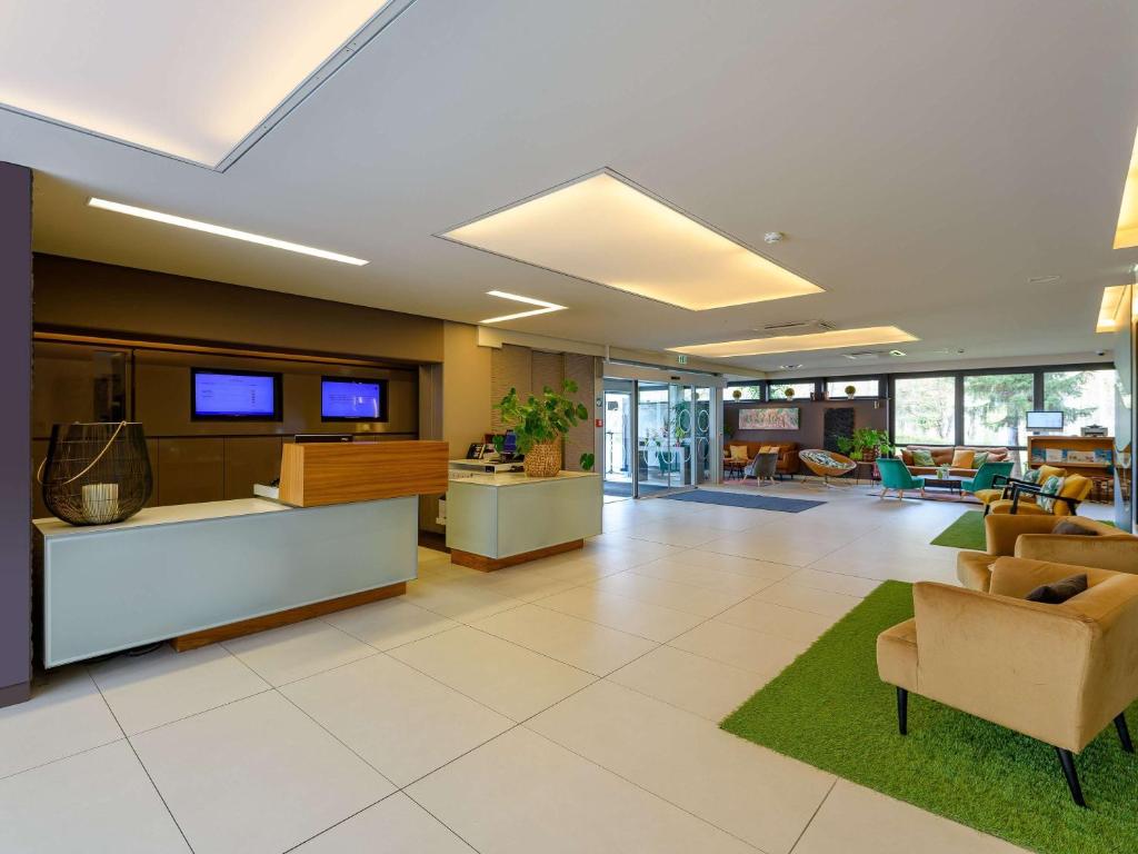 ein Büro mit einer Lobby mit Sofas und Stühlen in der Unterkunft Novotel Nürnberg am Messezentrum in Nürnberg