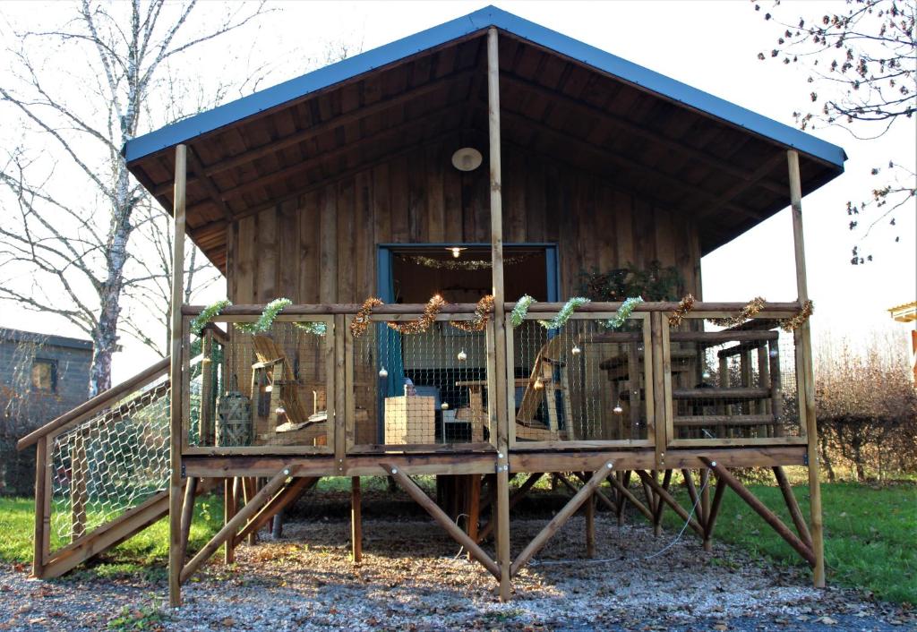 een speelhuis met een speeltuin in de tuin bij Tiny house - Cabane sur pilotis - Etat Nature in Magnières