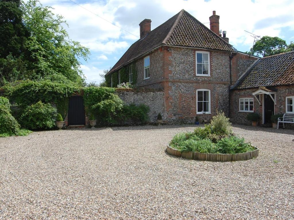 una casa antigua con un jardín delante de ella en Grange Farm en Thetford