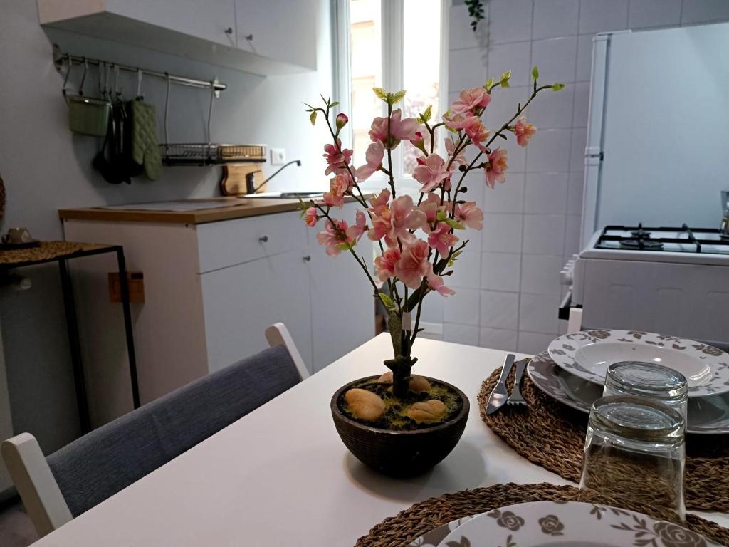 een tafel met een vaas met roze bloemen erop bij Casa Paolina a Metro San Paolo in Rome
