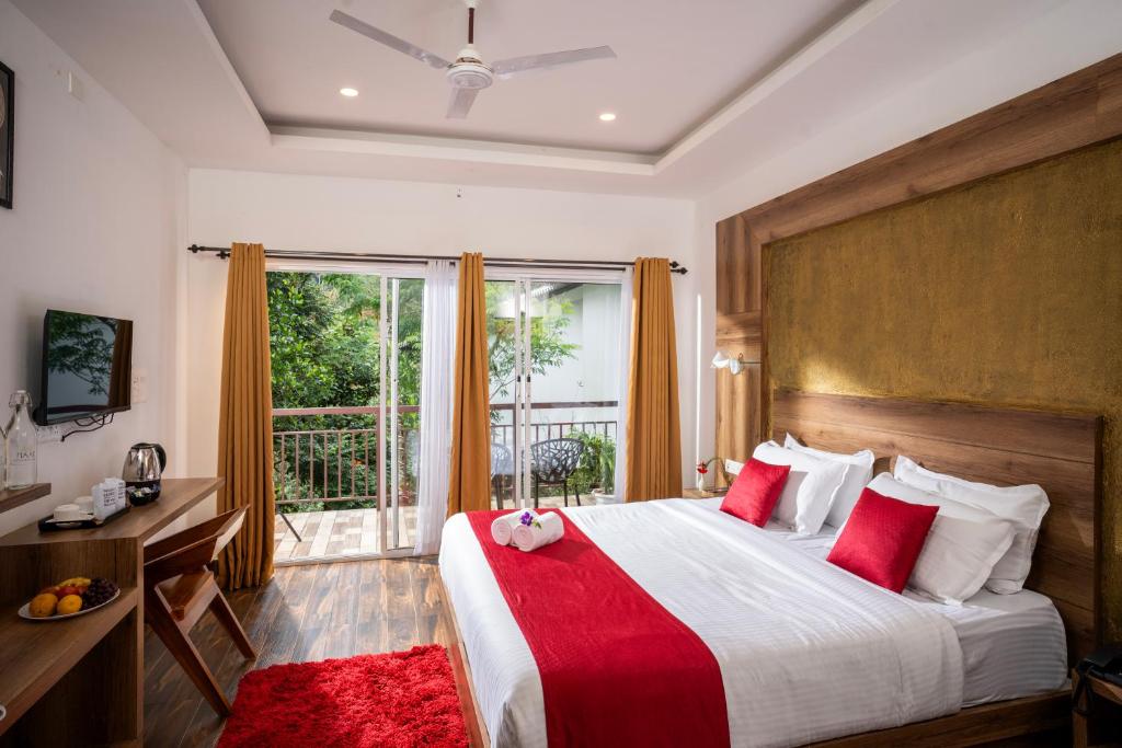 1 dormitorio con 1 cama grande con almohadas rojas en Wild Poetry, en Munnar