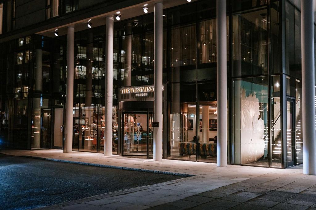 una tienda frente a un edificio por la noche en The Westminster London, Curio Collection by Hilton, en Londres