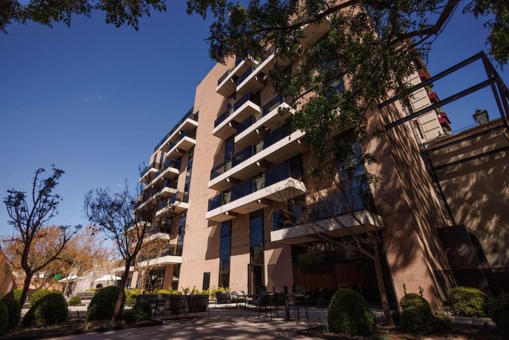 an apartment building in front of a street at Hualta Hotel Mendoza, Curio Collection by Hilton in Mendoza