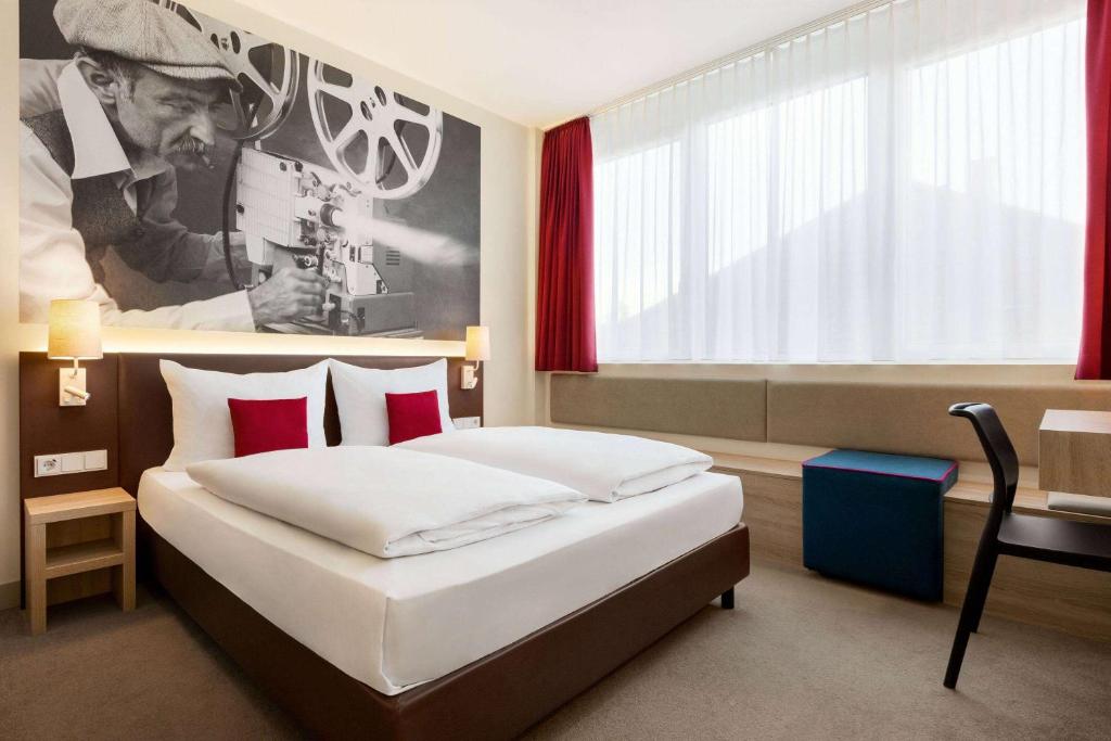a hotel room with two beds and a window at City Hotel MAX Munich West in Munich