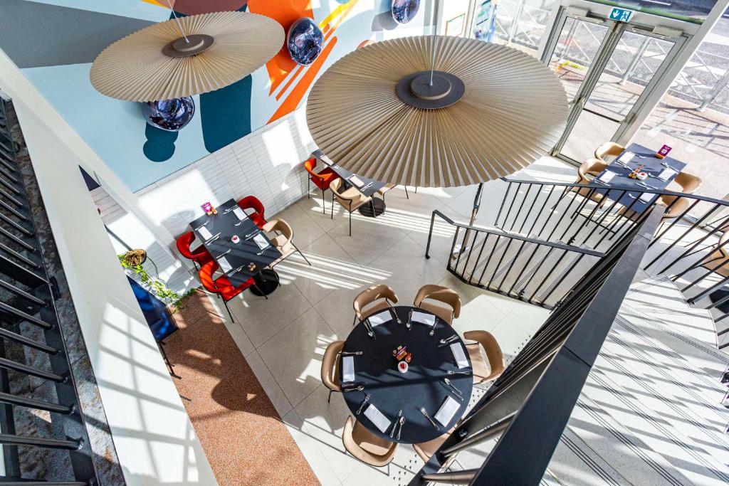 an overhead view of a restaurant with tables and umbrellas at Hotel Lille Euralille - Hilton Affiliate Hotel in Lille