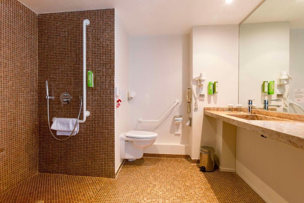 a bathroom with a toilet and a shower and a sink at Hotel Lille Euralille - Hilton Affiliate Hotel in Lille