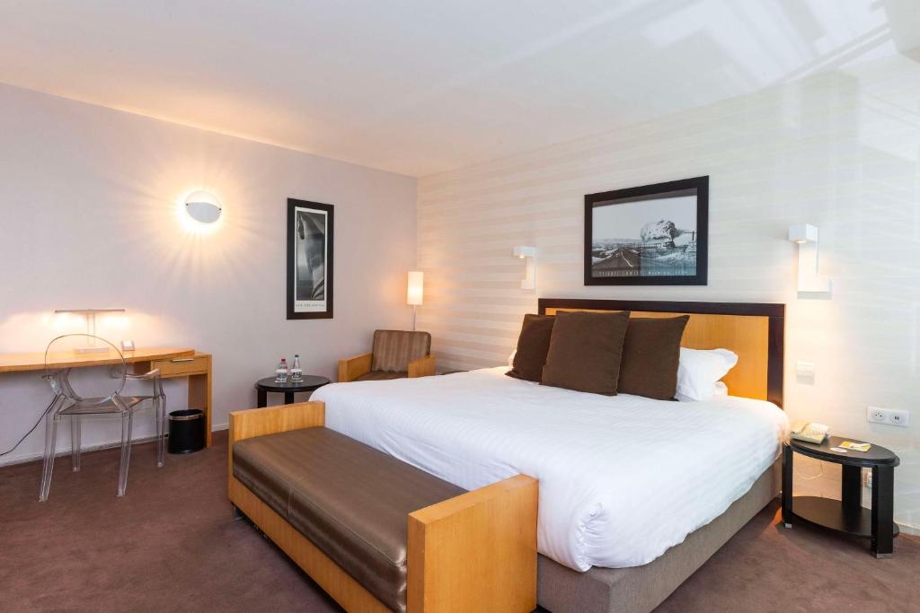 a hotel room with a large bed and a desk at Hotel Lille Euralille - Hilton Affiliate Hotel in Lille