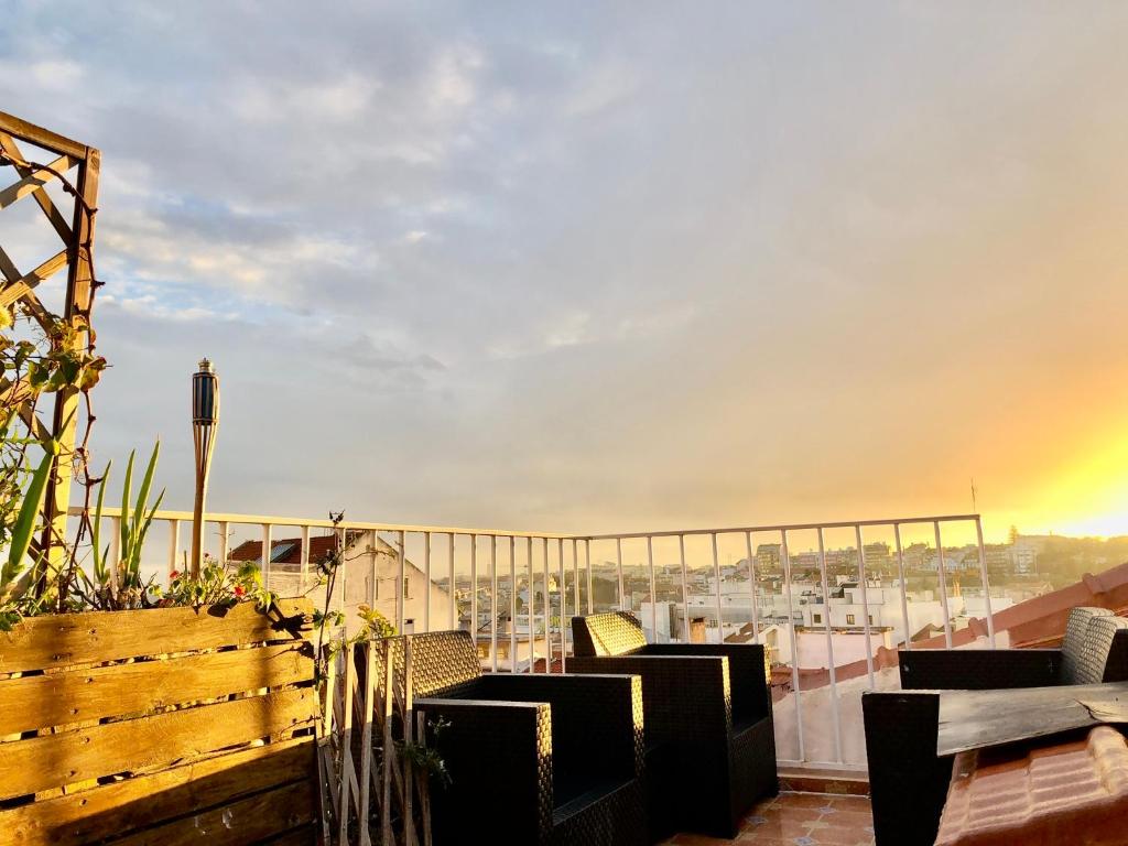 a balcony with chairs and a view of a city at Eddie Rooftop Lisbon center in Lisbon