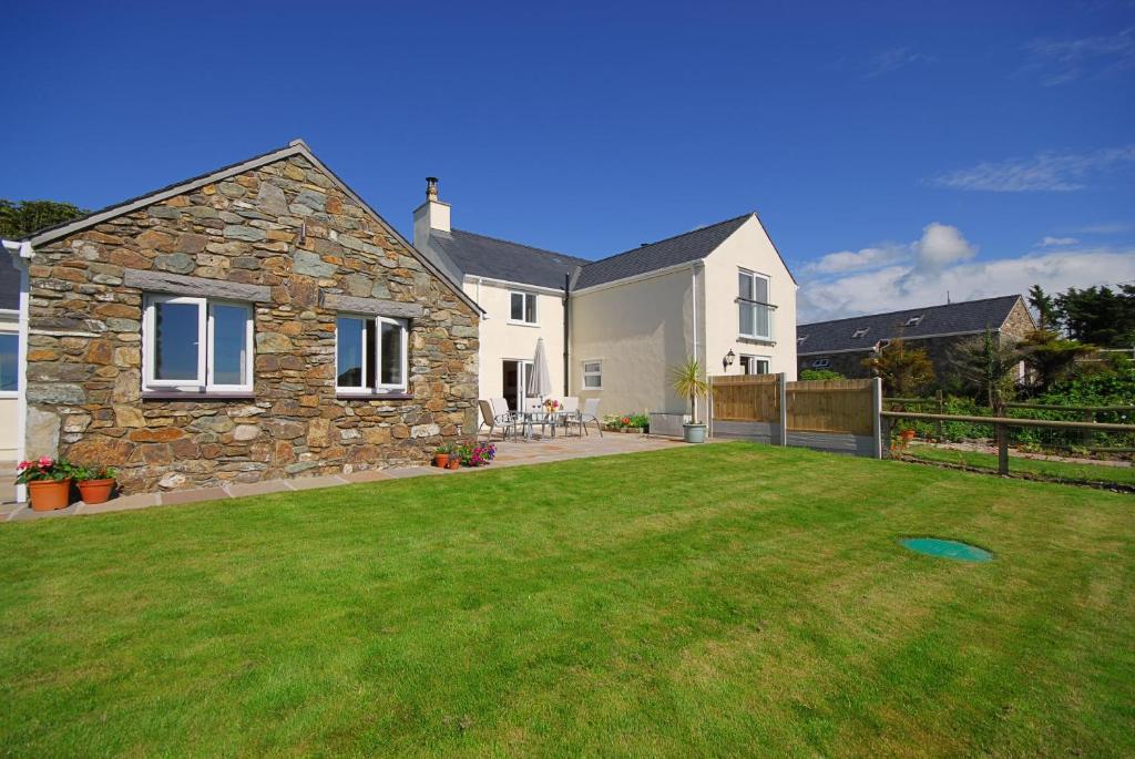 a house with a large lawn in front of it at Gadlys Cottage Sea Views Dog Friendly in Holyhead