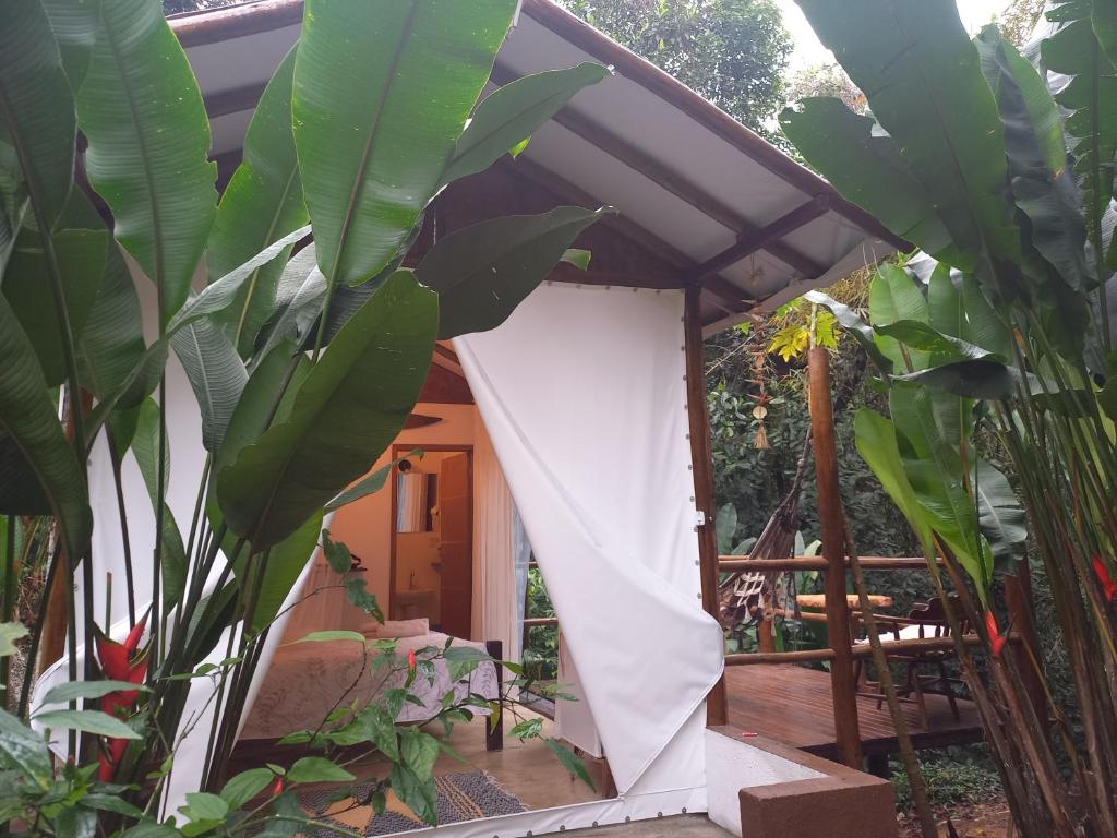 a house with a white door and some plants at Acqua Jungle Lodge, Bangalô na selva in Abraão
